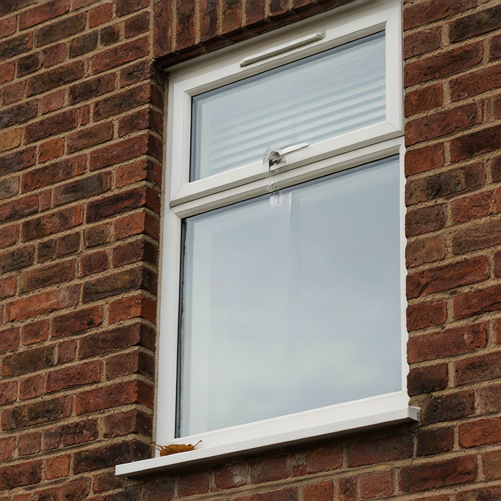 Detailopname van een wit kunststof kozijn met ingefreesd ventilatierooster