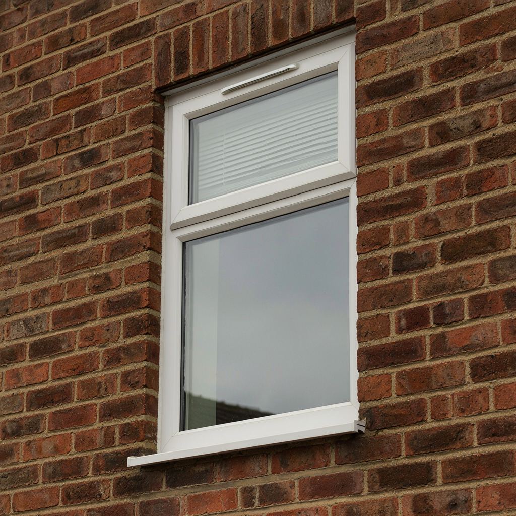Detailfoto wit kunststof kozijn met ventilatierooster en handgreep