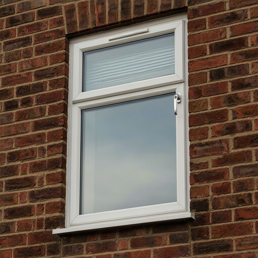 Close-up van een wit kunststof kozijn met ingebouwd ventilatierooster en espagnoletslot